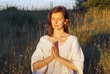 © Marianna Jaszczuk/ADDICTIVE STOCK - Serene female in dress sitting with prayer hands in field and meditating while doing yoga with closed eyes in summer