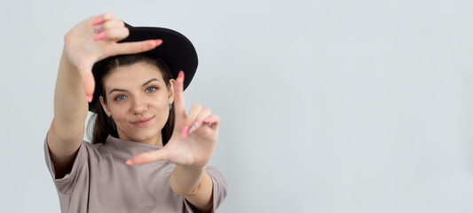 Creative good-looking woman using imagination picturing new appartment design how capture you making finger frame looking through, smiling white background