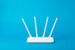 Wi-Fi router with four white antennas on a blue background.