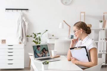 Wall Mural - Psychologist working with family online while sitting in office