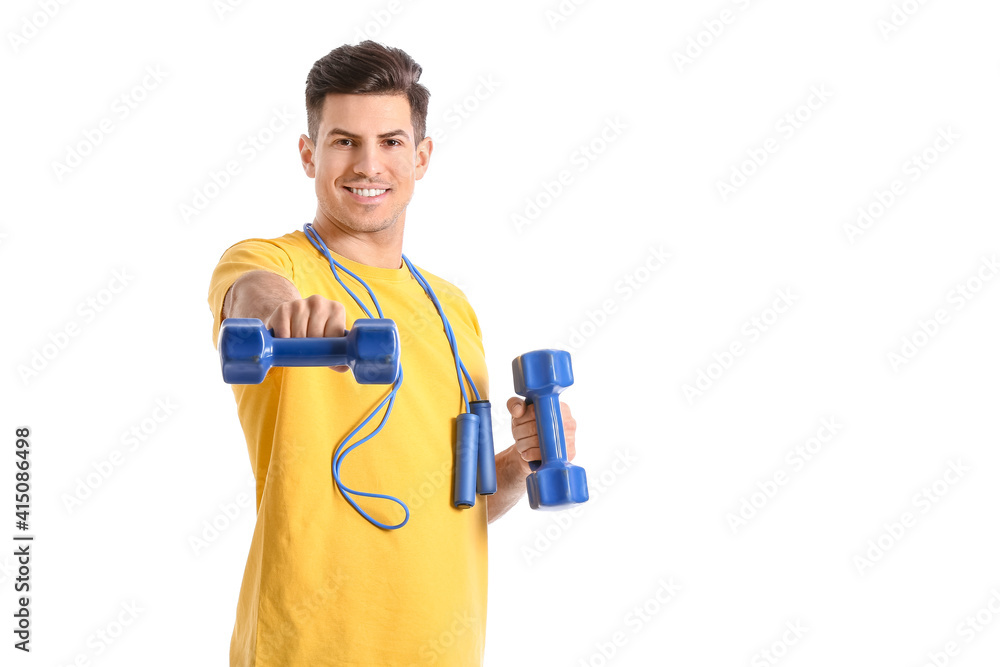 Sporty young man training with dumbbells on white background