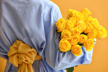 Young Woman With Beautiful Yellow Roses On Color Background, Back View
