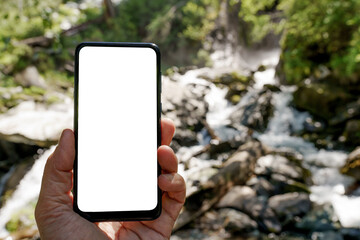 smart phone in hand on the blur background of waterfall