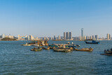 Fototapeta Big Ben - Xiamen Haicang Bay Park landscapes, Fishing Boats on the ocean and Xiamen City Skyline at distance