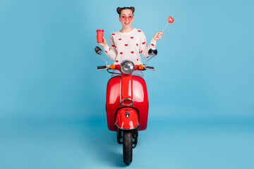 Poster - Photo of lady drive moped hold cup candy stick wear glasses heart print white pullover isolated blue background