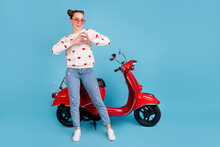 Full Size Photo Of Young Brautiful Girl In Glasses Smiling Show Heart Sign Stand Near Moped Isolated On Blue Color Background