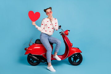 Canvas Print - Full size photo of pretty brunette bun haired girl hold heart sit bike send air kiss wear casual outfit isolated on blue color background