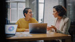 © Gorodenkoff - Two Diverse Multiethnic Female Have a Discussion in Meeting Room Behind Glass Walls in an Agency. Creative Director and Project Manager Compare Business Results on Laptop and App Designs in an Office.