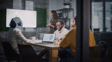 Aufkleber - Project Manager Makes a Presentation for a Young Diverse Creative Team in Meeting Room in an Agency. Colleagues Sit Behind Conference Table and Discuss Business Development, Sales Analysis and Design.