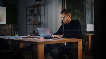 Aufkleber - Handsome Caucasian Male is Working on Laptop Computer while Sitting Behind a Conference Table in Meeting Room in an Creative Agency. Project Manager is Busy With Business Strategy and Development.
