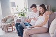 © deagreez - Profile side photo of positive adorable sweet pretty family waiting baby sitting sofa hugging tummy talking modern device indoors inside