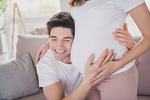 Close-up Portrait Of Nice Dreamy Cheery Tender Gentle Spouses Waiting Baby Guy Listening Tummy Heart Beat In Light House Flat Indoor