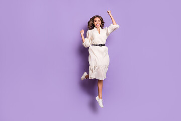 Wall Mural - Full length body size photo of girl smiling jumping high gesturing like winner isolated on pastel purple color background