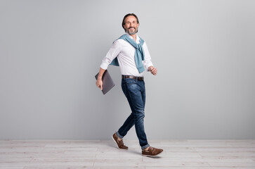 Poster - Full length body size photo of man wearing casual outfit walking with laptop smiling isolated on pastel grey color background