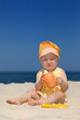 Baby girl sitting on the sandy beach