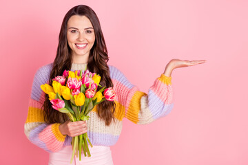 Poster - Portrait of pretty cheerful trendy girl holding tulips on palm copy empty space offer advert isolated over pink pastel color background