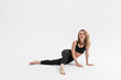 © Artem Bruk - Sporty blonde woman sitting on floor after exercising yoga on white background
