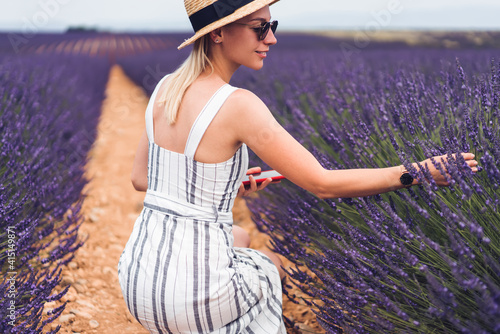 Glad female explorer enjoying lavender flowers