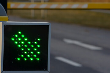 Green glowing arrow at a border crossing with yellow barriers