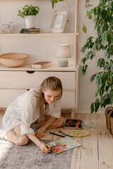 Wall Mural - Portrait of a young woman painting at home