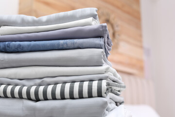 Stack of clean linens in bedroom, closeup