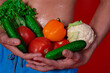 © Denis - A beautiful male body and natural vegetables. Diet and nutrition. Orange background. Broccoli, tomatoes, cucumbers, peppers and lettuce.
