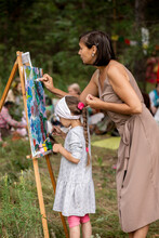 Happy Little Girl In The Plein Air With Her Mom