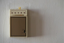 An Old, Analog Temperature Control Thermostat Is Shown On A Wall Up Close, With Text Or Copy Space To The Right.