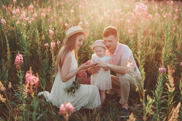 a happy family walks through a flower meadow. Love and spring blooming