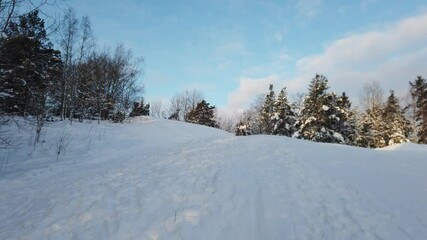 Wall Mural - The sun has just risen in a cloudy sky over the snowy hill in Scandinavia