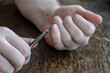 © Mikhail - An adult man is cutting his hand nails with manicure scissors.
