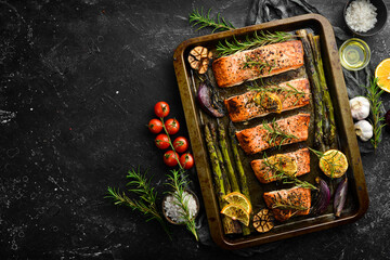 Salmon baked in a metal tray with vegetables and rosemary. Recipe. Seafood. Free space for text.