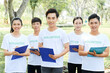 © DragonImages - Group of volunteers with their leader standing in park with clipboard in hands and looking at camera