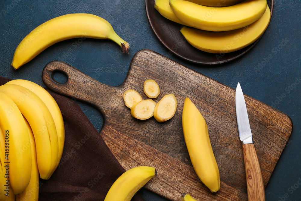 Wooden board with bananas on dark background