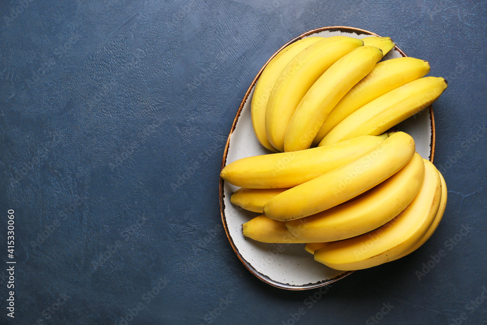 Plate with ripe bananas on dark background