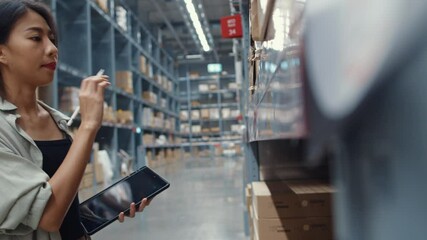 Wall Mural - Attractive young Asia businesswoman manager looking for goods using digital tablet checking inventory levels standing in retail shopping center. Distribution, Logistics, Packages ready for shipment.