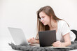 © Andriy Medvediuk - A smiling young girl in glasses sits with a laptop. Education, remote work and blogging. Isolated on a white background.