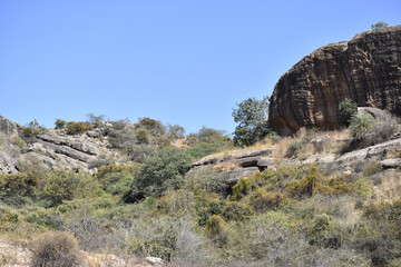 Poster - Huge rock formation in a desert landscape and a blue sky