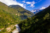 Fototapeta Na sufit - deep green and rugged valley and a whitewater river with large mountains in the background in Nepal