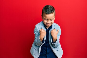 Wall Mural - Little kid boy wearing elegant business jacket celebrating surprised and amazed for success with arms raised and eyes closed