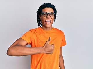 Young african american man wearing casual clothes and glasses doing happy thumbs up gesture with hand. approving expression looking at the camera showing success.