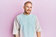 © Krakenimages.com - Young caucasian man wearing casual clothes looking away to side with smile on face, natural expression. laughing confident.