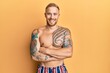 © Krakenimages.com - Young caucasian man wearing swimwear shirtless happy face smiling with crossed arms looking at the camera. positive person.