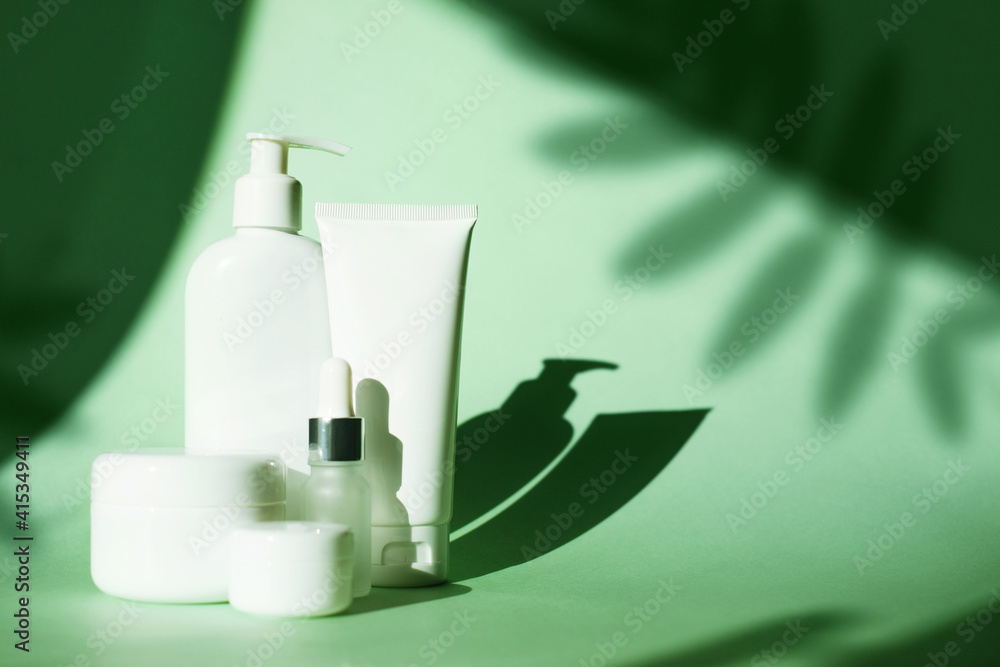 Set of cosmetic bottle cream jar, gel, lotion on green background with ...