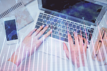 Double exposure of woman hands working on computer and forex graph hologram drawing. Top View. Financial analysis concept.