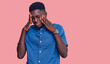 © Krakenimages.com - Young african american man wearing casual clothes with hand on head, headache because stress. suffering migraine.