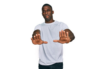 Young african american man wearing casual white t shirt doing stop gesture with hands palms, angry and frustration expression