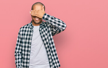 Sticker - Hispanic adult man wearing casual clothes smiling and laughing with hand on face covering eyes for surprise. blind concept.