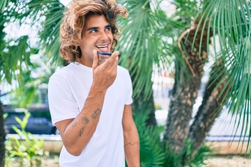 Wall Mural - Young hispanic man having conversation talking on the smartphone at street of city