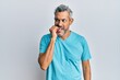 © Krakenimages.com - Middle age grey-haired man wearing casual clothes looking stressed and nervous with hands on mouth biting nails. anxiety problem.